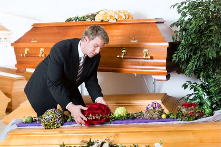 un croque mort prépare un cercueil