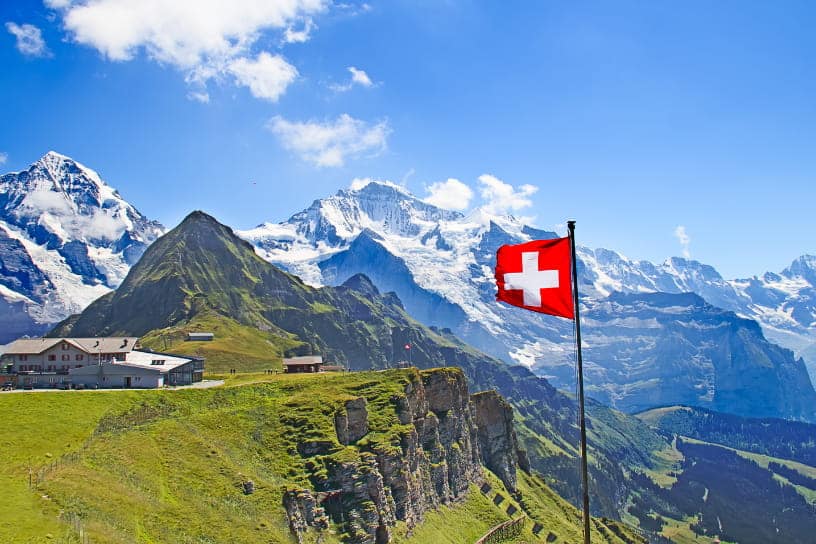 drapeau suisse devant des montagnes